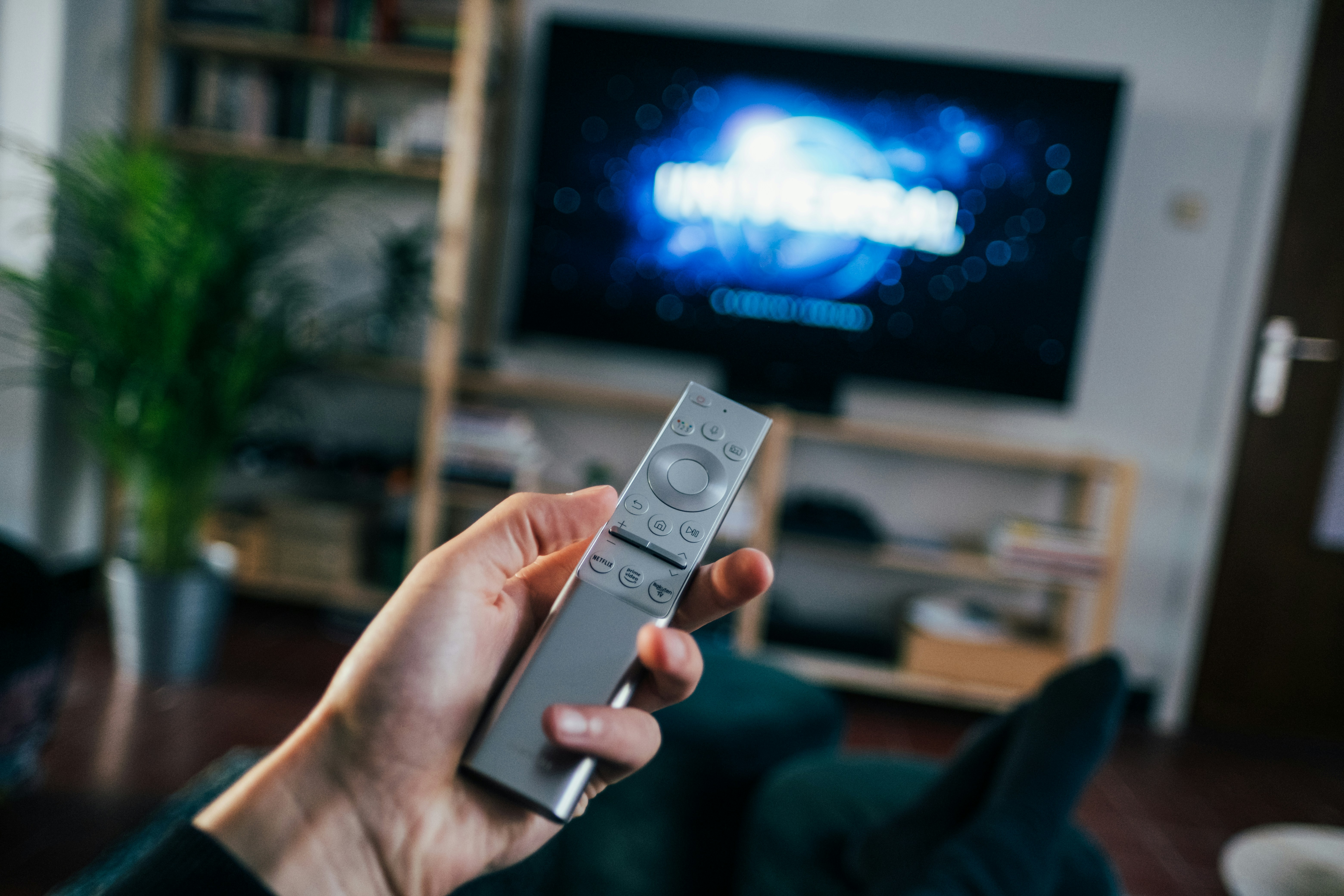 Person holding a remote control while watching TV